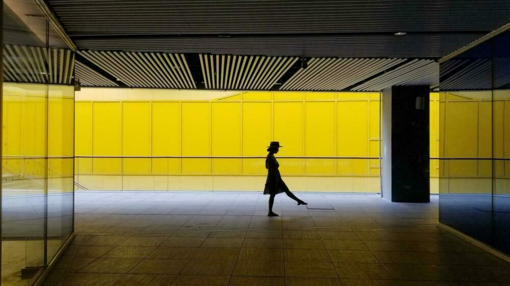 Silhouette einer Frau in einer gelben U-Bahn.