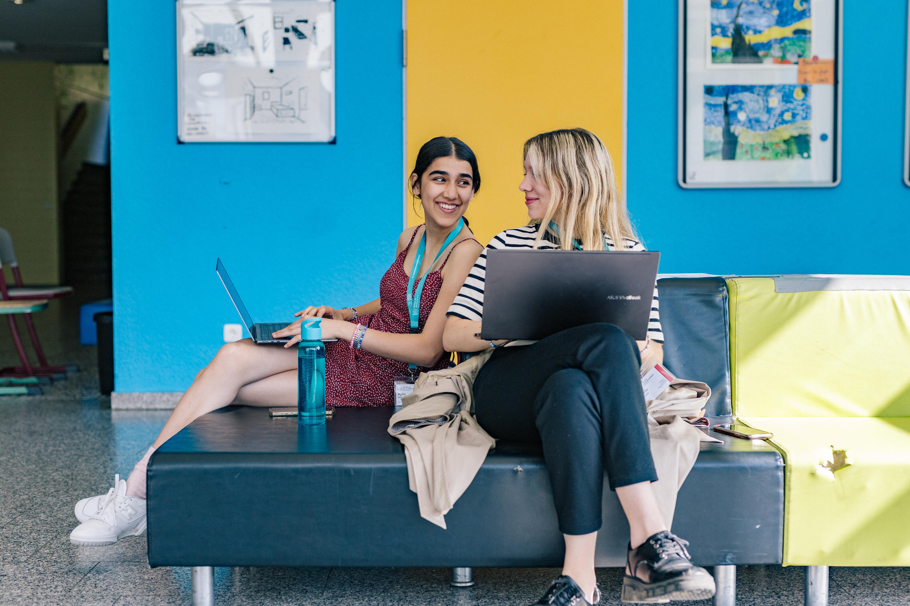 Zwei Mädchen arbeiten an Laptops auf dem Flur