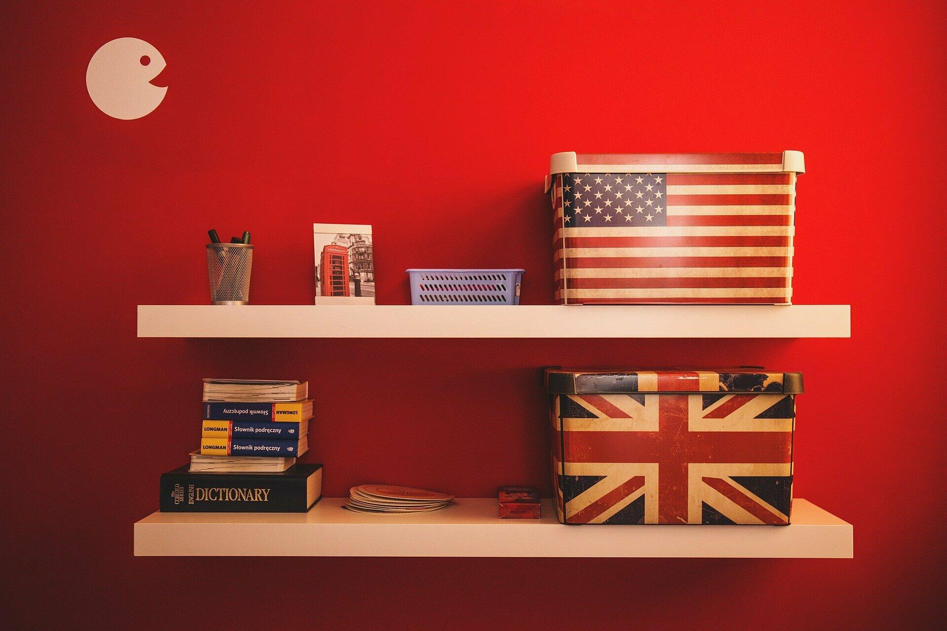 Schachteln mit amerikanischer Flagge im Regal vor roter Wand.