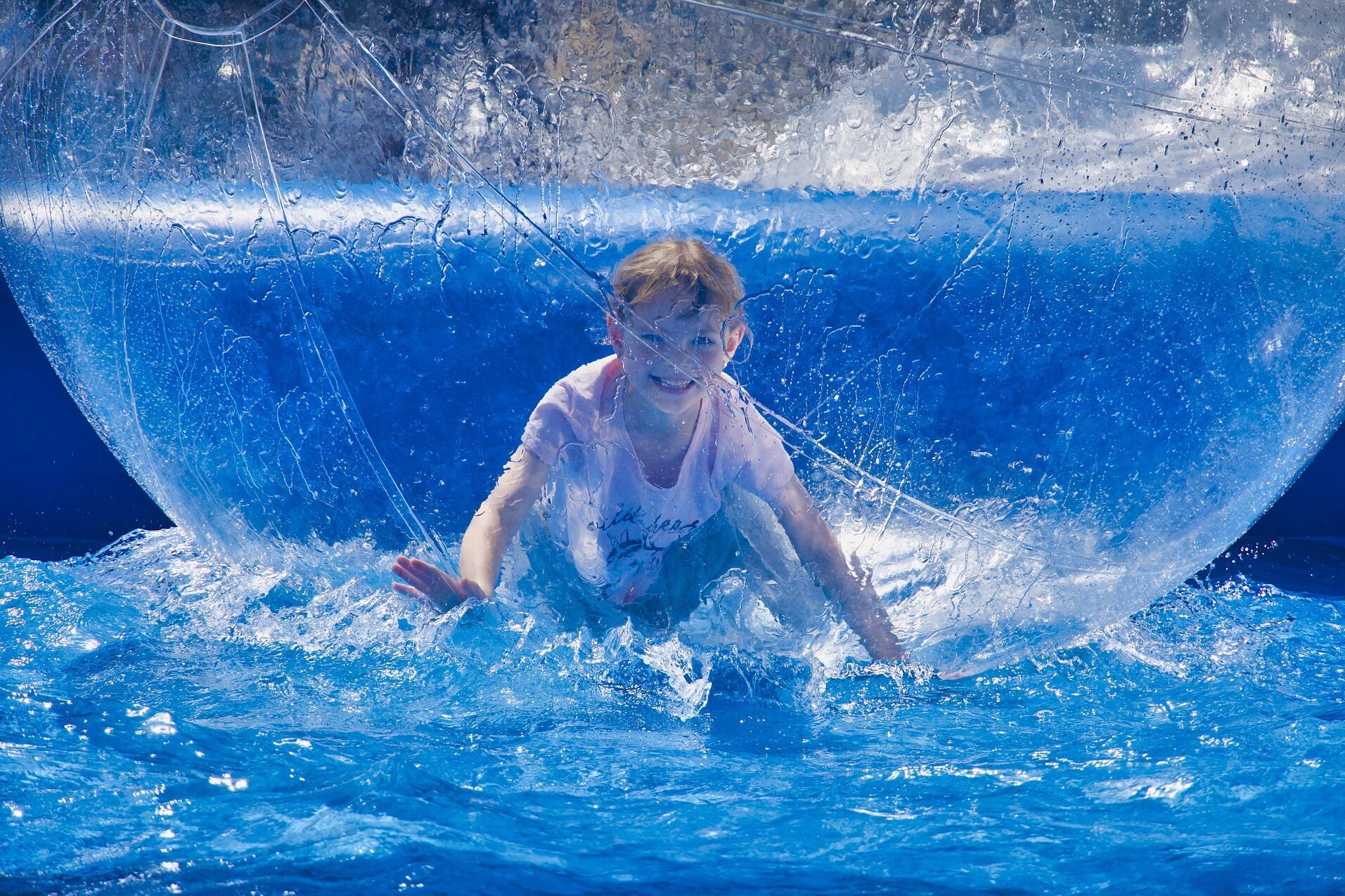 Kind in einem Wasserlaufball im Pool