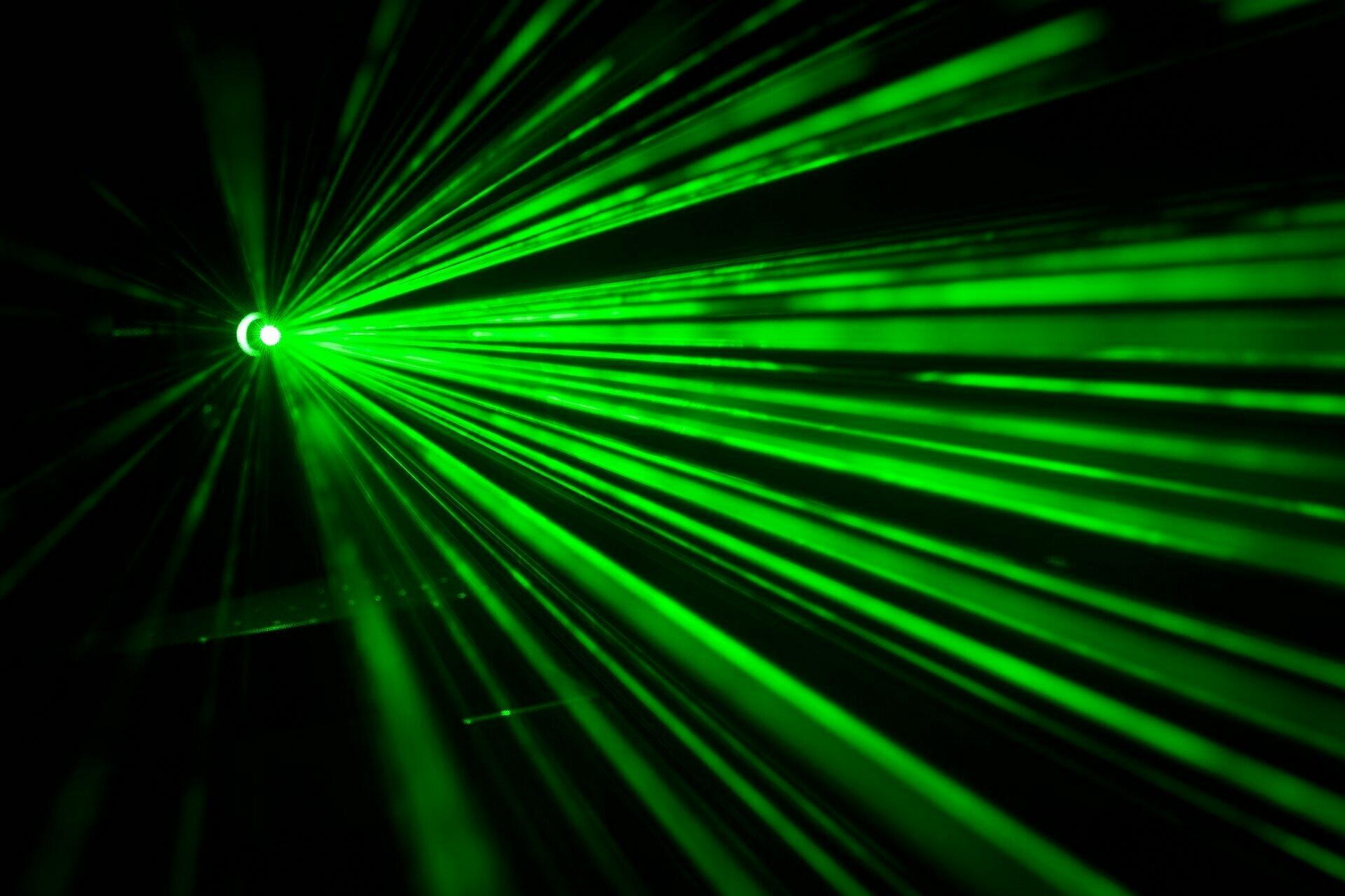 Grüne Laserstrahlen vor schwarzem Hintergrund