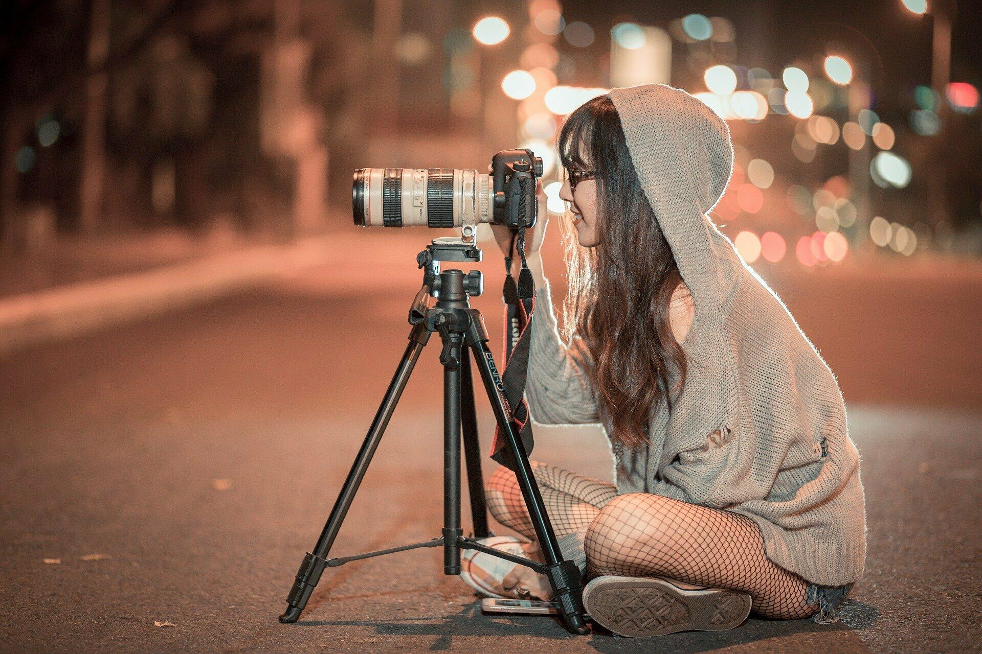 Ein junges Mädchen, das nachts fotografiert.