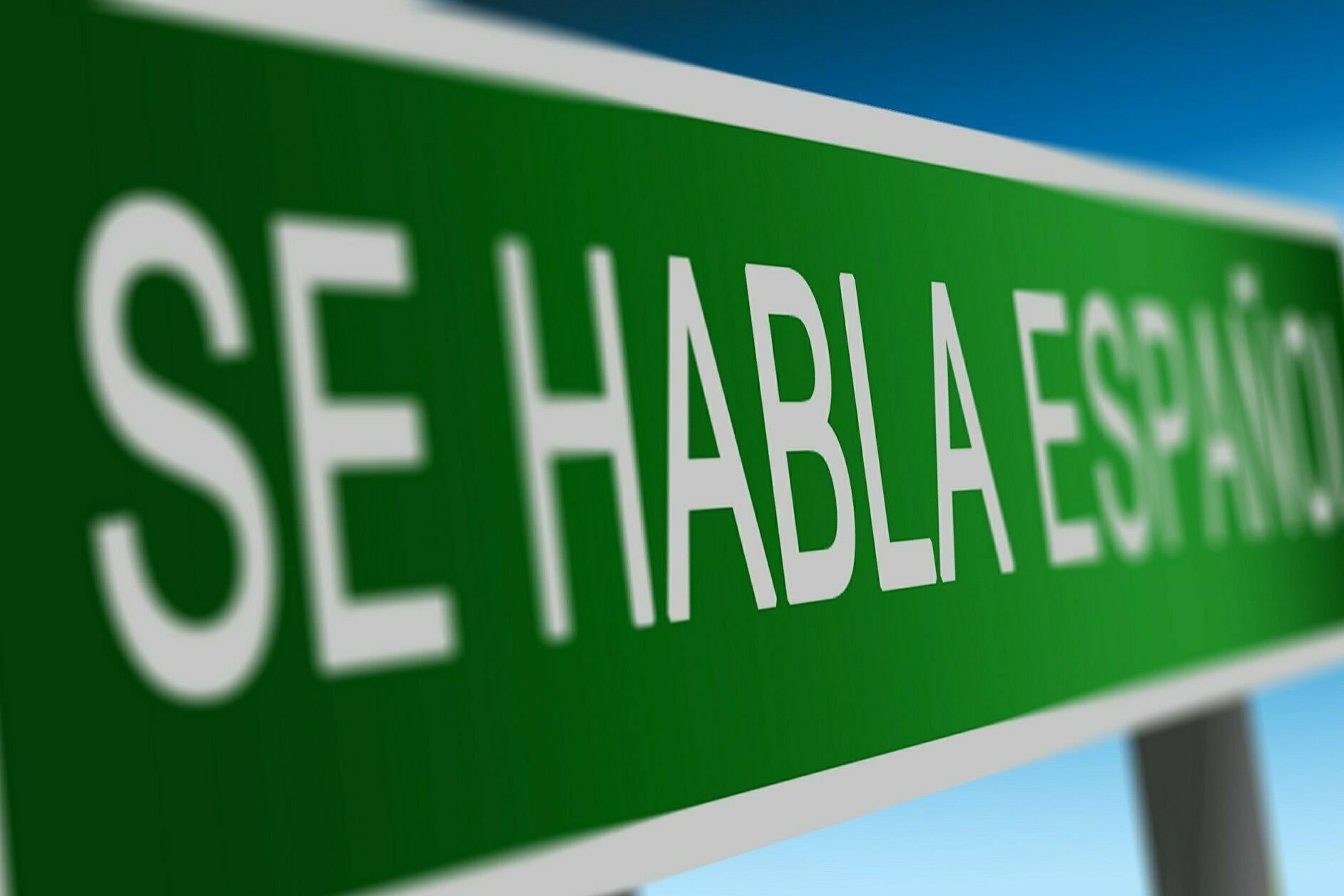 Grünes Schild mit der Aufschrift "SE HABLA ESPANOL".