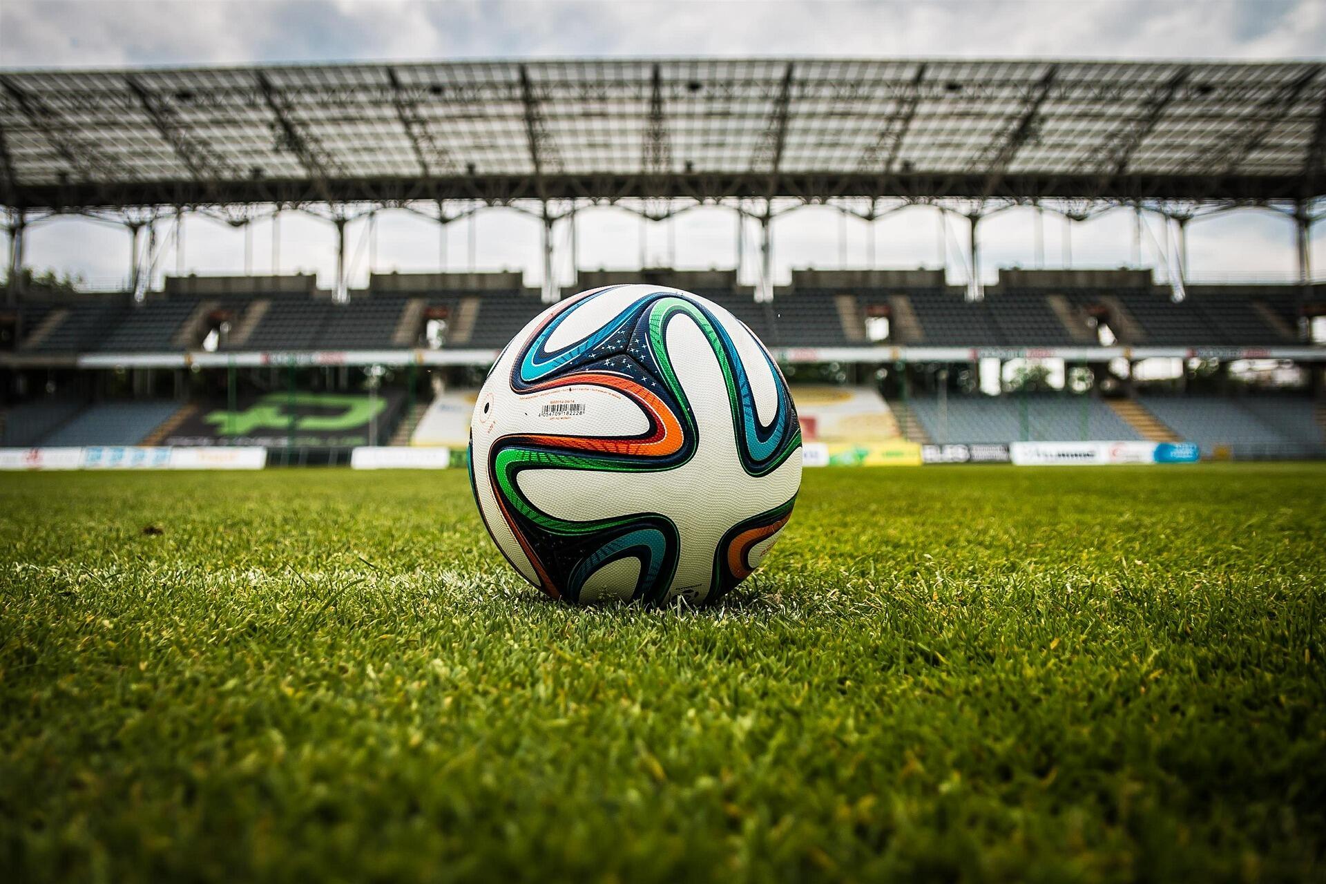 Abbildung eines Fußballs auf dem grünen Rasen eines Stadions
