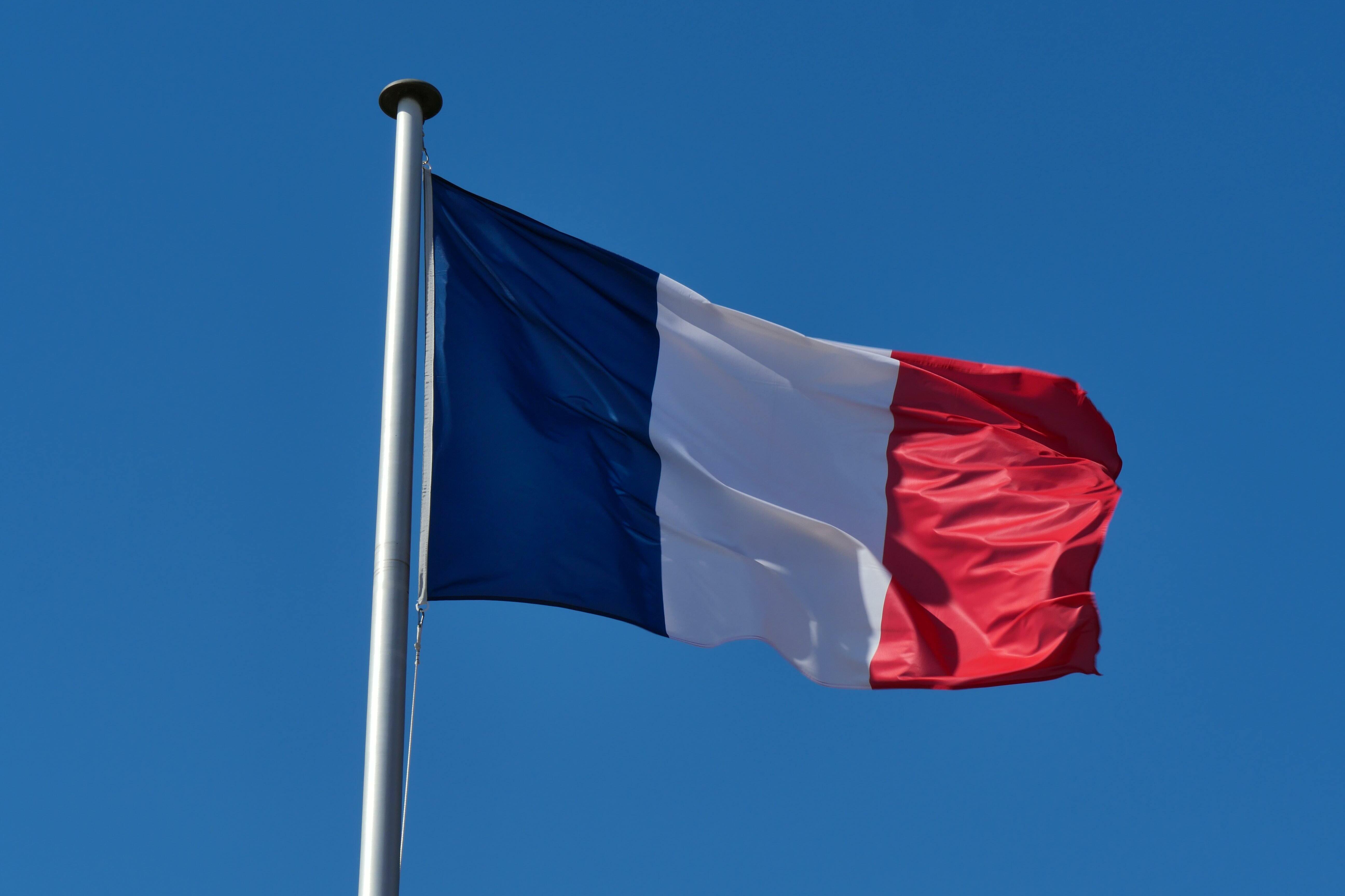 Französische Flagge vor blauem Himmel.